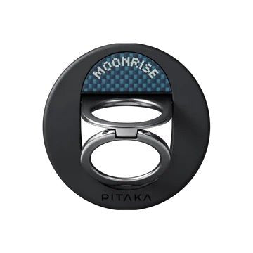A black circular Pitaka MagSafe Phone Ring Moonrise with a dual-loop design and a blue patterned tab.