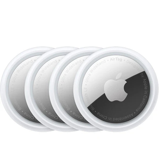 Vier Apple AirTags sind in einer Reihe gestapelt und weisen das runde Design von Apple auf, mit einem metallischen Zentrum, das das Apple-Logo zeigt, und einem weißen Außenrand.