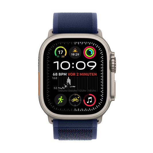 Die Apple Watch Ultra 2 GPS + Cellular (49 mm, Titan natur) mit blauem Trail-Armband (S/M) zeigt Gesundheitsdaten wie Herzfrequenz, Schritte, Trainingsringe, Musik und Zeit auf einem lebendigen Hauptbildschirm mit bunten App-Symbolen und digitalen Anzeigen an.