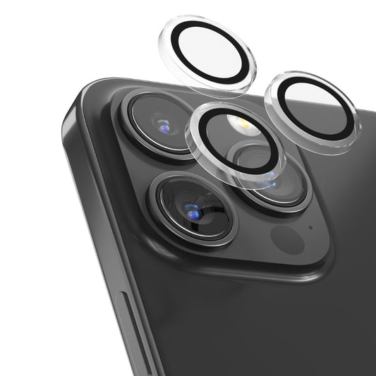 Eine Nahaufnahme des DEVIA Devia Peak Series Crystal Kameraschutzes für iPhone 16 Pro & Pro Max, die drei kreisförmige Linsenschützer zeigt, die über jeder Kameralinse schweben, bereit zum Anbringen.