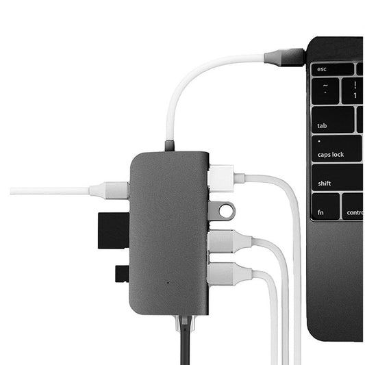 Eine Nahaufnahme eines LMP USB-C mini Dock space grau von LMP, angeschlossen an ein MacBook Pro, mit mehreren Kabeln und Geräten - einschließlich eines HDMI 4K-Kabels - an seinen Anschlüssen.
