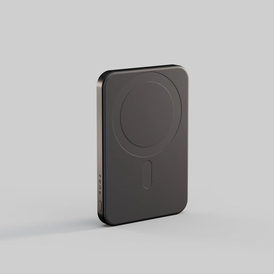 The Zens Powerbank Pro Magsafe in Schwarz stands upright on a light gray background, featuring Qi2-Magnettechnologie, 5.000 mAh capacity, circular outline, side port, and a sleek rectangular design with rounded edges.