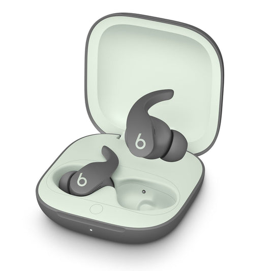 Ein Paar Apple Beats Fit Pro komplett kabellose In-Ear Kopfhörer in Grau, mit Ohrbügeln und komfortablem Sitz, liegt in einem passenden offenen Ladecase mit stylisiertem b Logo - ideal für ganztägigen Musikgenuss.