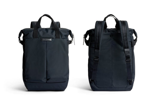 Beyaz bir arka plan üzerinde, Bellroy Tokyo Totepack Compact modelinin lacivert renginin iki farklı görünümü gösterilmektedir: önden bakıldığında tutma sapları ve ön cep göze çarparken, arkadan bakıldığında yastıklı omuz askıları ve ayarlanabilir tokalar görülmektedir. Bellroy’un bu su itici sırt çantası, cihazların güvenli bir şekilde saklanması için özel bir dizüstü bilgisayar bölmesine de sahiptir.