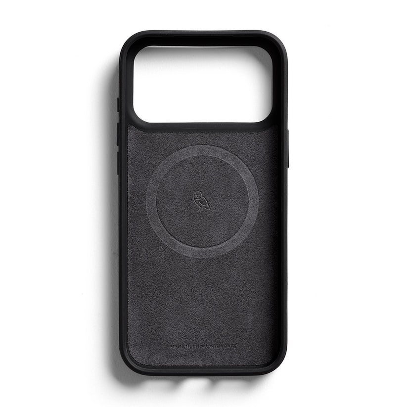 Eine schwarze, rechteckige Bellroy-Hülle für das iPhone 17 Pro Max (0 Karten) verfügt über eine offene Vorderseite, ein kreisförmiges Innendesign mit dem charakteristischen Vogel-Logo in der Mitte und den Schriftzug „WORKS BEAUTIFULLY WITH iPHONE 17 Pro Max“ nahe der Unterkante. Diese MagSafe-kompatible Hülle von Bellroy gewährleistet nahtloses Laden und die Verwendung von Zubehör.