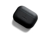 Eine schwarze, rechteckige „Bellroy AirPods Jacket Pro (2. Generation)“-Hülle mit abgerundeten Kanten aus hochwertigem Leder ist vor einem weißen Hintergrund zu sehen, wobei ein Schatten nach links fällt.