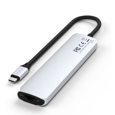 Ein silberner Satechi USB-C 7-in-1 Slim Multiport-Adapter mit Ethernet-Anschluss verfügt über ein kurzes, schwarz geflochtenes Kabel und mehrere Anschlüsse – darunter einen Ethernet-Anschluss – an einem Ende. Der elegante Satechi-Adapter trägt auf seiner Oberfläche die FCC- und CE-Kennzeichnungen.