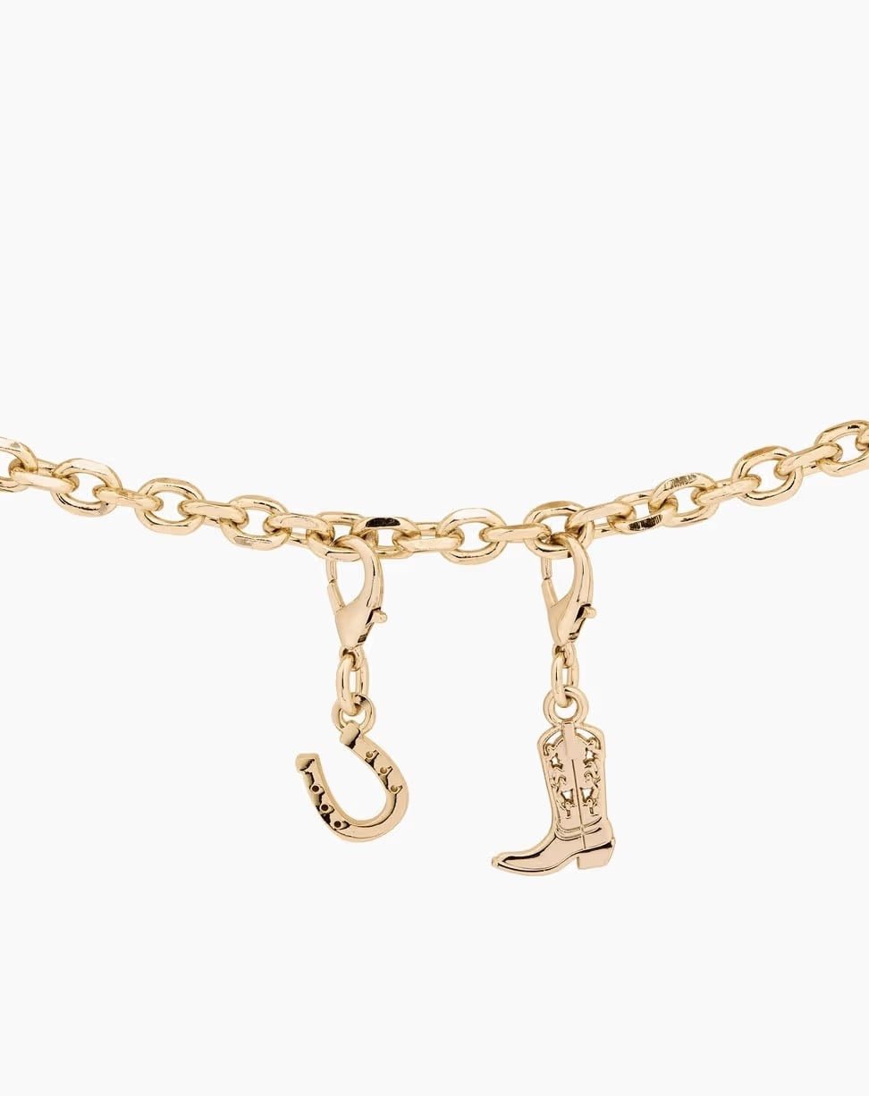 Verleihen Sie Ihrem Stil einen Hauch von Glück und Flair mit dem „Ideal of Sweden Anhänger Glücksbringer – Gold“: einem Armband mit goldener Kette und zwei Anhängern – einem Hufeisen und einem Cowboystiefel mit Stern-Details. Inspiriert von der „Glücksbringer Gold“-Kollektion von Ideal of Sweden ist dieser „Handy Charm“ das perfekte stilvolle Accessoire.