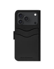 Eine stilvolle und funktionale schwarze Klapphülle mit MagSafe von Ideal of Sweden für das iPhone 17 Pro/18 Pro, ausgestattet mit zwei Kartenfächern und einem geprägten Markenlogo im unteren Bereich, die Ihr Smartphone sicher schützt.