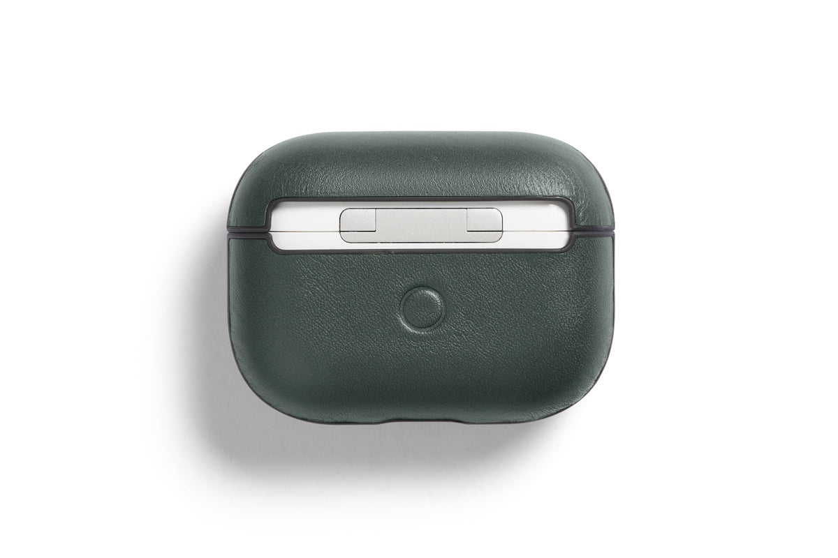 Eine dunkelgrüne, maßgeschneiderte Bellroy AirPods Jacket Pro (2. Generation) – Everglade-Hülle aus hochwertigem Leder mit einem runden Knopf auf der Vorderseite ist geschlossen und von oben vor einem weißen Hintergrund abgebildet.