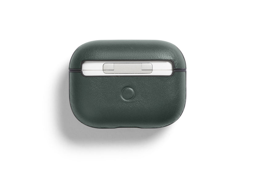 Eine dunkelgrüne, maßgeschneiderte Bellroy AirPods Jacket Pro (2. Generation) – Everglade-Hülle aus hochwertigem Leder mit einem runden Knopf auf der Vorderseite ist geschlossen und von oben vor einem weißen Hintergrund abgebildet.