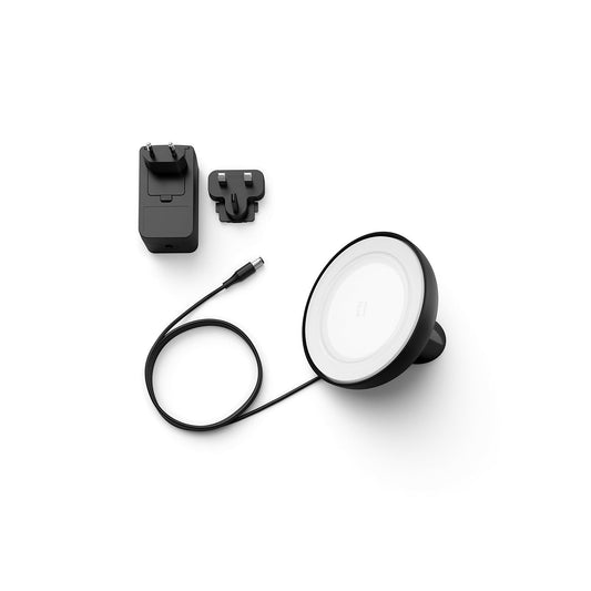 Ein schwarzes kabelloses Ladepad mit USB-C-Kabel, Netzadapter und austauschbarem Stecker wird auf weißem Hintergrund angezeigt - ideal für Ladegeräte wie die Philips Hue Bloom Tischleuchte, schwarz von Philips.