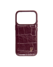 Eine „Ideal of Sweden“-Hülle aus veganem Leder mit MagSafe für das iPhone 18 Pro Max in der Farbe „Fine Wine Croco“, mit Krokodilprägung in Maroon-Farbe, goldener Markenprägung am unteren Rand, offenem Design an der Oberseite und präzisem Kameraausschnitt.
