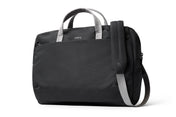 Wir stellen vor: die Bellroy Via Work Bag (Tech Briefcase) – Slate: Eine elegante schwarze Laptoptasche von Bellroy mit grauen Griffen und einem passenden, verstellbaren Schultergurt. Das minimalistische Design wird durch ein dezentes Bellroy-Logo oben in der Mitte abgerundet. Diese stilvolle Business-Tasche bietet ausreichend Platz für deinen Laptop und eignet sich ideal für den täglichen Gebrauch.