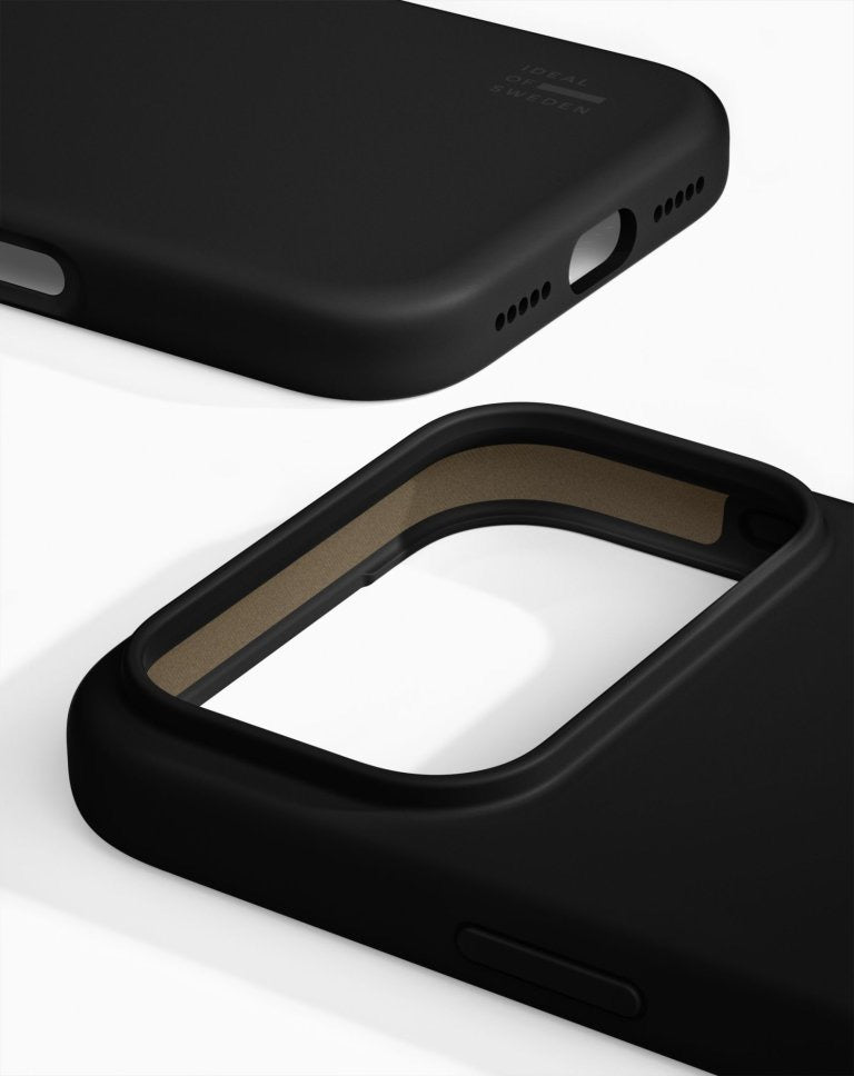 Close-up of two black Ideal of Sweden MagSafe Silikonhülle cases for iPhone 17 Pro Max/18 Pro Max, one highlighting the camera cutout and side button, the other displaying the bottom edge with speaker holes and a charging port cutout, both set against a white background. These cases by Ideal of Sweden combine elegant protection with impeccably crafted details.