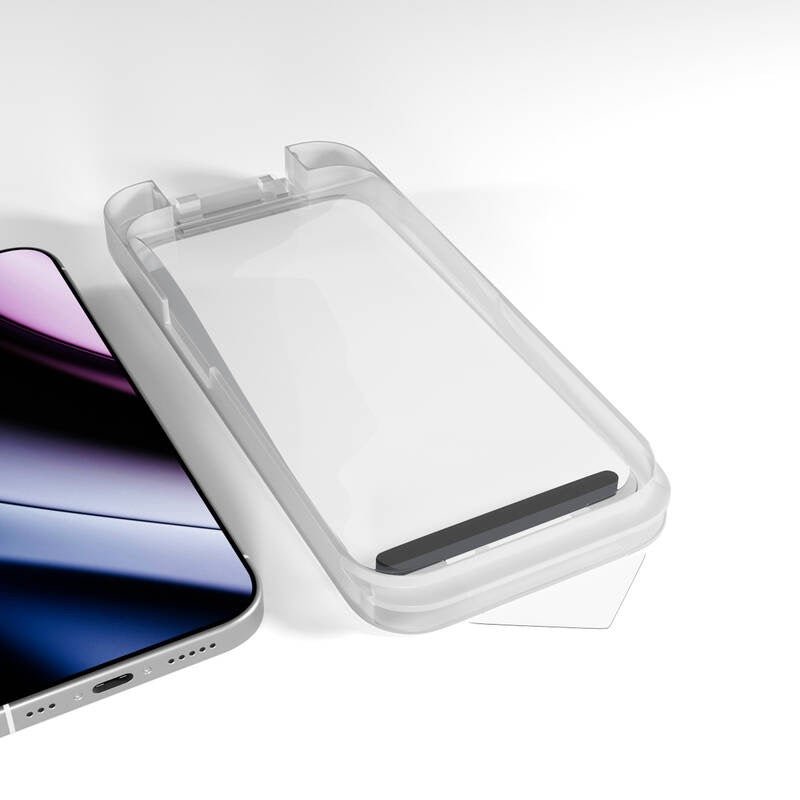An iPhone rests beside a transparent plastic screen protector tray with a black alignment bar at one end, both arranged on a white surface—components of the Epico Panzerglas für iPhone 18 Pro Max / 17 Pro Max mit Installationskit from Epico, designed for optimal display protection.