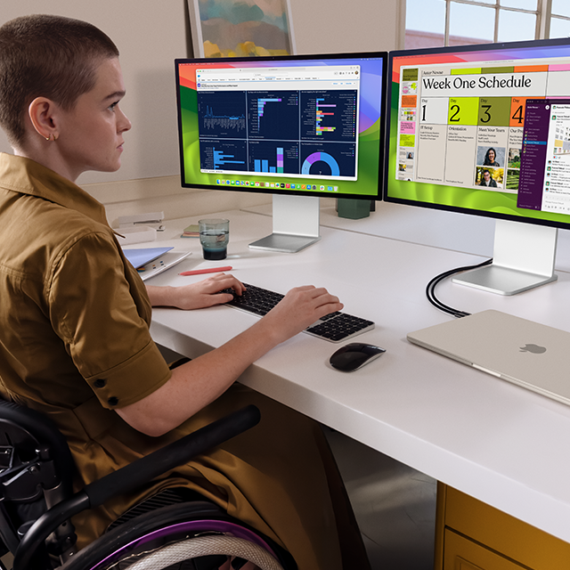 Eine Person arbeitet an zwei externen Displays, die an ein zugeklapptes 15&quot MacBook Air in Polarstern angeschlossen sind