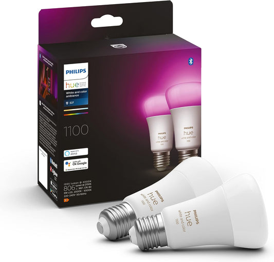 Zwei Philips Hue White & Col. Amb. E27 Doppelpack 75W LED-Glühbirnen werden vor ihrer Verpackung ausgestellt, auf der die Marke Philips, das Bluetooth-Logo und eine lebendige Smart Home Beleuchtung in Pink- und Violetttönen zu sehen sind.