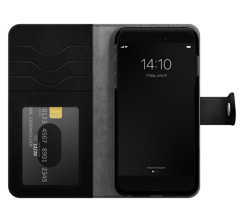 A black Ideal of Sweden Magnet Wallet+ case, made from vegan materials, holds an iPhone SE on the right and three cards on the left, including a visible chip card with numbers. The phone shows the time 14:10 and the date Friday, June 6.
