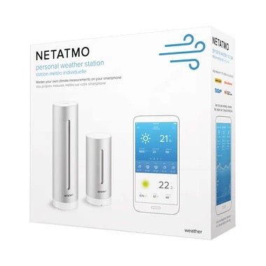 Eine Verpackung für die Netatmo Smarte Wetter-Station von Netatmo mit zwei zylindrischen Sensoren und einem Smartphone, das die Klimadaten anzeigt. Die Produktangaben auf der Verpackung sind auf Englisch und Französisch.