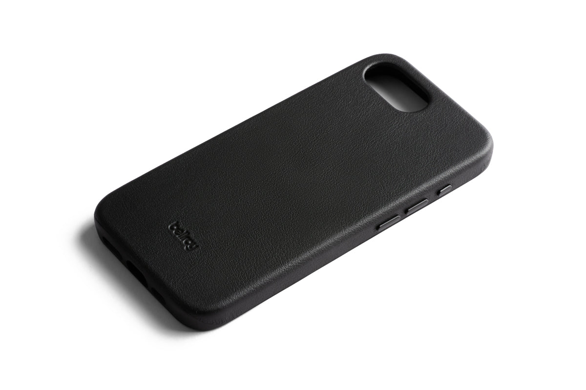 Eine schwarze Bellroy-Handyhülle – Modell „0 Card“ für das iPhone 16e/17e – ist vor einem weißen Hintergrund abgebildet. Diese elegante Lederhülle von Bellroy verfügt über präzise Aussparungen für Kamera, Tasten und Anschlüsse sowie ein dezent geprägtes Bellroy-Logo in der unteren Ecke. Die Hülle ist zudem MagSafe-kompatibel und ermöglicht so ein müheloses Aufladen Ihres Geräts.
