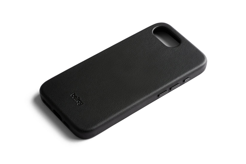 Eine schwarze Bellroy-Handyhülle – Modell „0 Card“ für das iPhone 16e/17e – ist vor einem weißen Hintergrund abgebildet. Diese elegante Lederhülle von Bellroy verfügt über präzise Aussparungen für Kamera, Tasten und Anschlüsse sowie ein dezent geprägtes Bellroy-Logo in der unteren Ecke. Die Hülle ist zudem MagSafe-kompatibel und ermöglicht so ein müheloses Aufladen Ihres Geräts.
