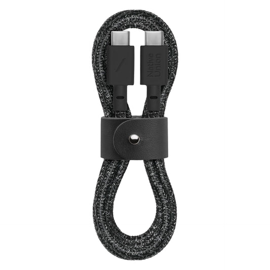 1,2 metrelik örgülü siyah USB-C - USB-C şarj kablosu olan Native Union Belt Cable (Cosmos modeli), güvenli saklama için çıtçıtlı siyah deri kayışa sahiptir ve konektörlerden birinde Native Union logosu bulunur.