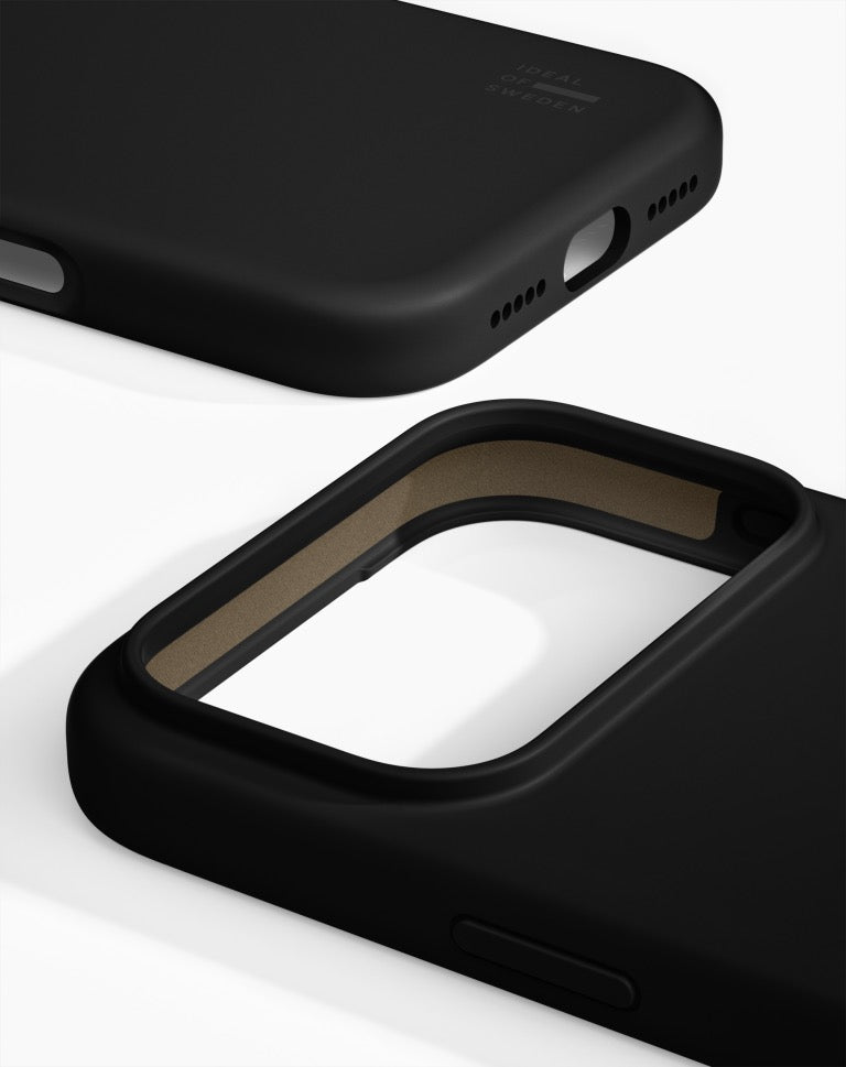 Ideal of Sweden’in iPhone 17 Pro/18 Pro için tasarladığı MagSafe Silikonhülle koleksiyonuna ait iki siyah kılıf, beyaz bir arka plan üzerinde yakın çekimde gösterilmektedir. Kılıflardan birinde kamera açıklığı net bir şekilde görülürken, diğerinde şarj girişi ve hoparlörler için hassas şekilde açılmış delikler göze çarpmaktadır. Her ikisi de mat bir yüzeye sahiptir ve Ideal of Sweden tarafından tasarlanmıştır.