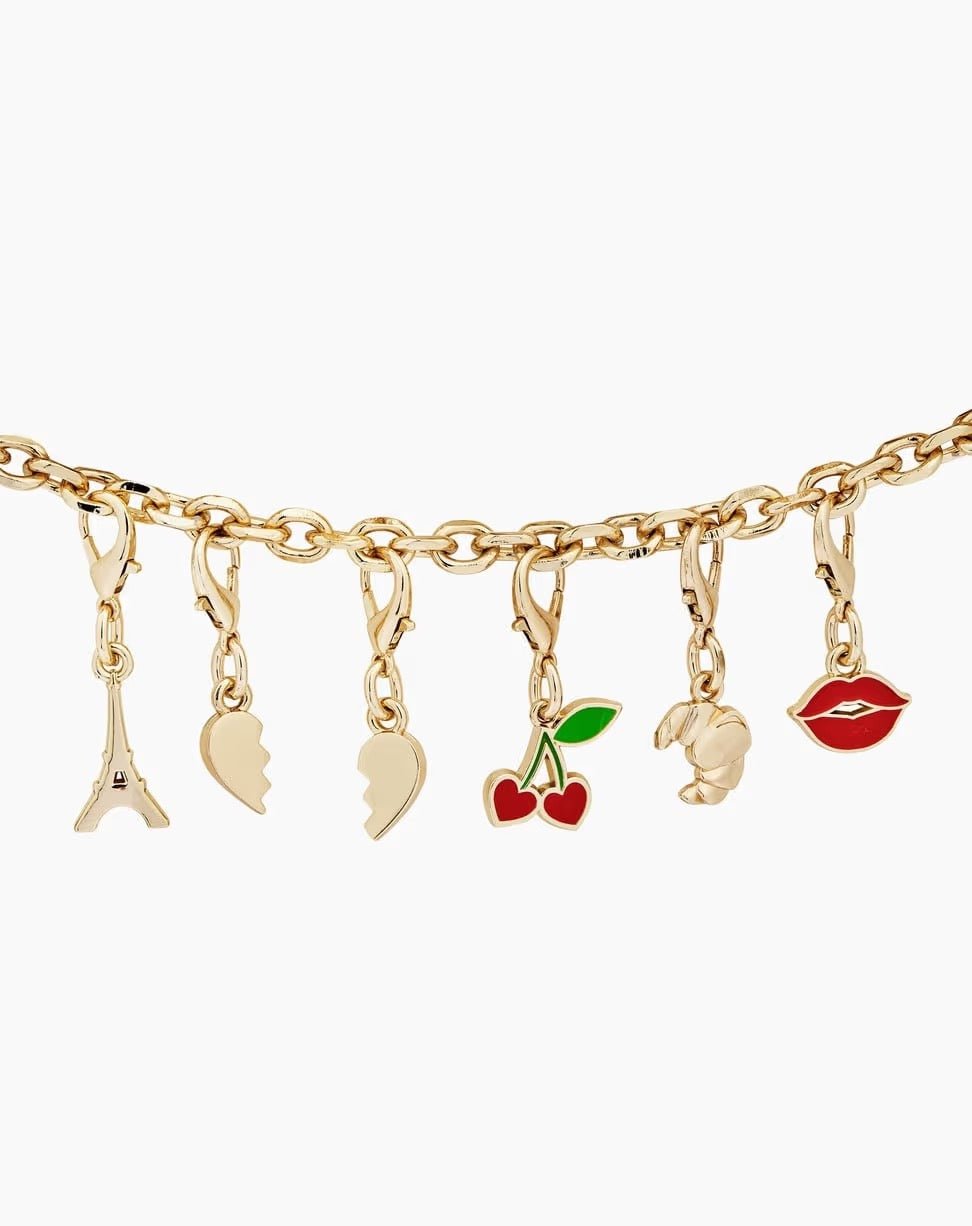 Ein goldenes Armband mit sechs verspielten Anhängern – dem Eiffelturm, zwei Hälften eines gebrochenen Herzens, Kirschen, einer Rose und roten Lippen – verkörpert den unverwechselbaren Stil von Ideal of Sweden. Für einen zusätzlichen Hauch von Pariser Flair ist das Armband zudem mit dem „Ideal of Sweden Anhänger Croissant“ in Gold verziert.