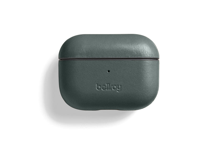 Eine Bellroy AirPods Jacket Pro (2. Generation) – Everglade aus dunkelgrünem Premium-Leder ist geschlossen auf einem weißen Hintergrund abgebildet. Auf der Vorderseite ist das geprägte Bellroy-Logo zu sehen, über dem sich eine kleine Kontrollleuchte befindet. Diese maßgeschneiderte Hülle bietet modernen Komfort mit USB-C-Aufladung.