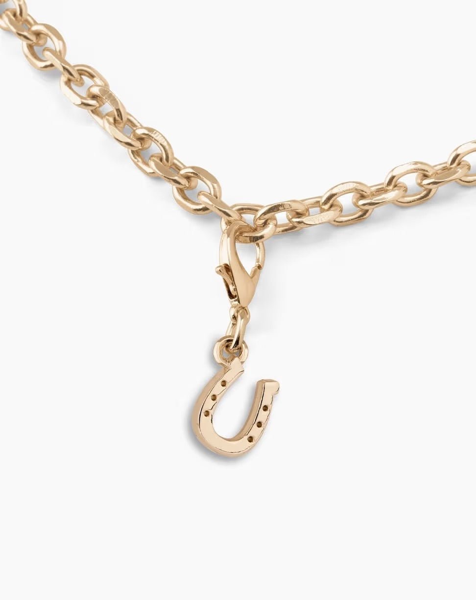 Die „Ideal of Sweden Anhänger Glücksbringer – Gold“ ist eine Halskette mit goldener Kette und Karabinerverschluss, an der ein eleganter Hufeisen-Anhänger hängt, der von der „Glücksbringer Gold“-Kollektion von Ideal of Sweden inspiriert ist und anmutig herabhängt, um einen Hauch von Glück und Stil zu verleihen.